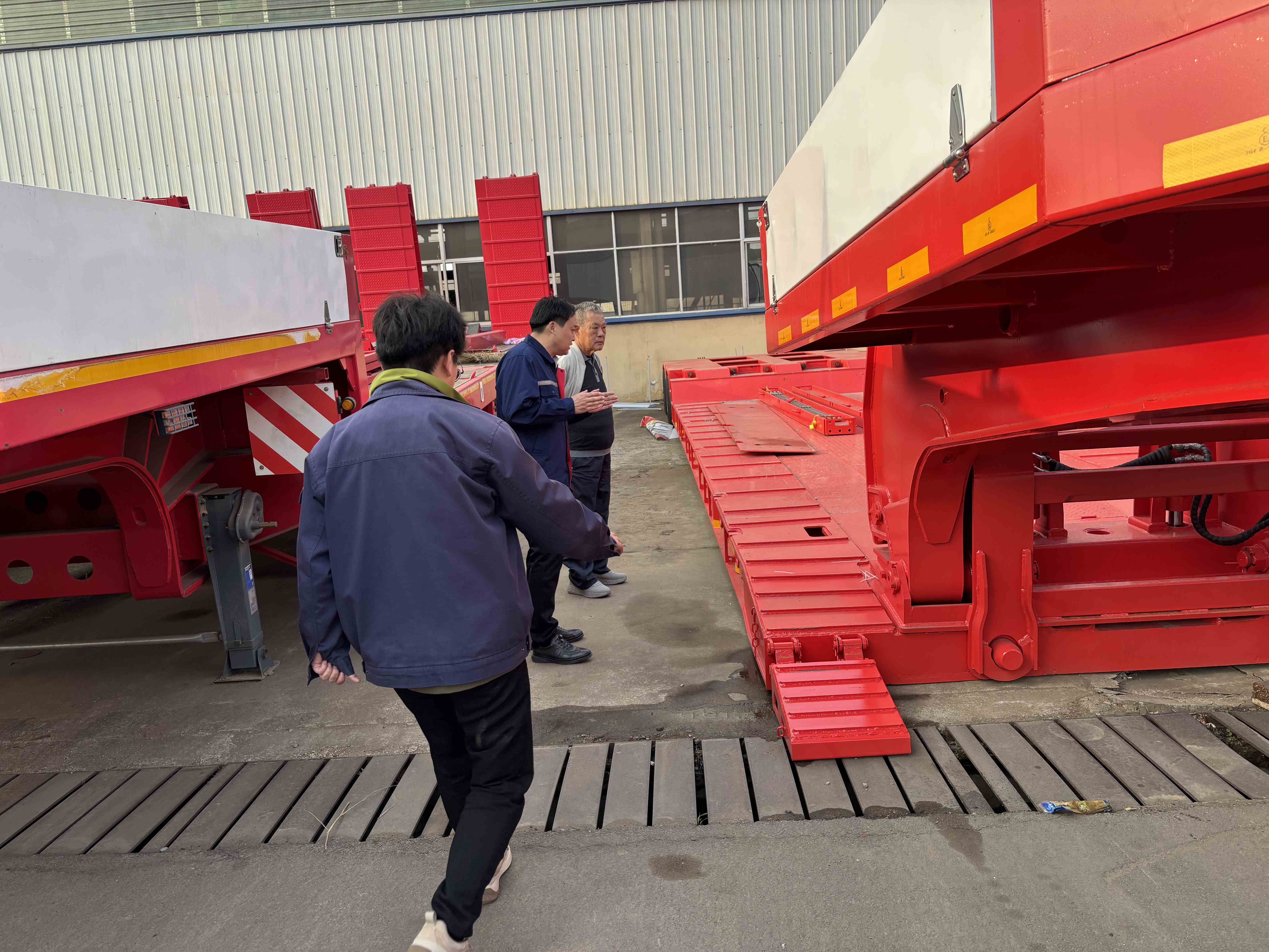 HUAYUE engineering team explaining the front-loading detachment mechanism of the 2 axle removable gooseneck trailer