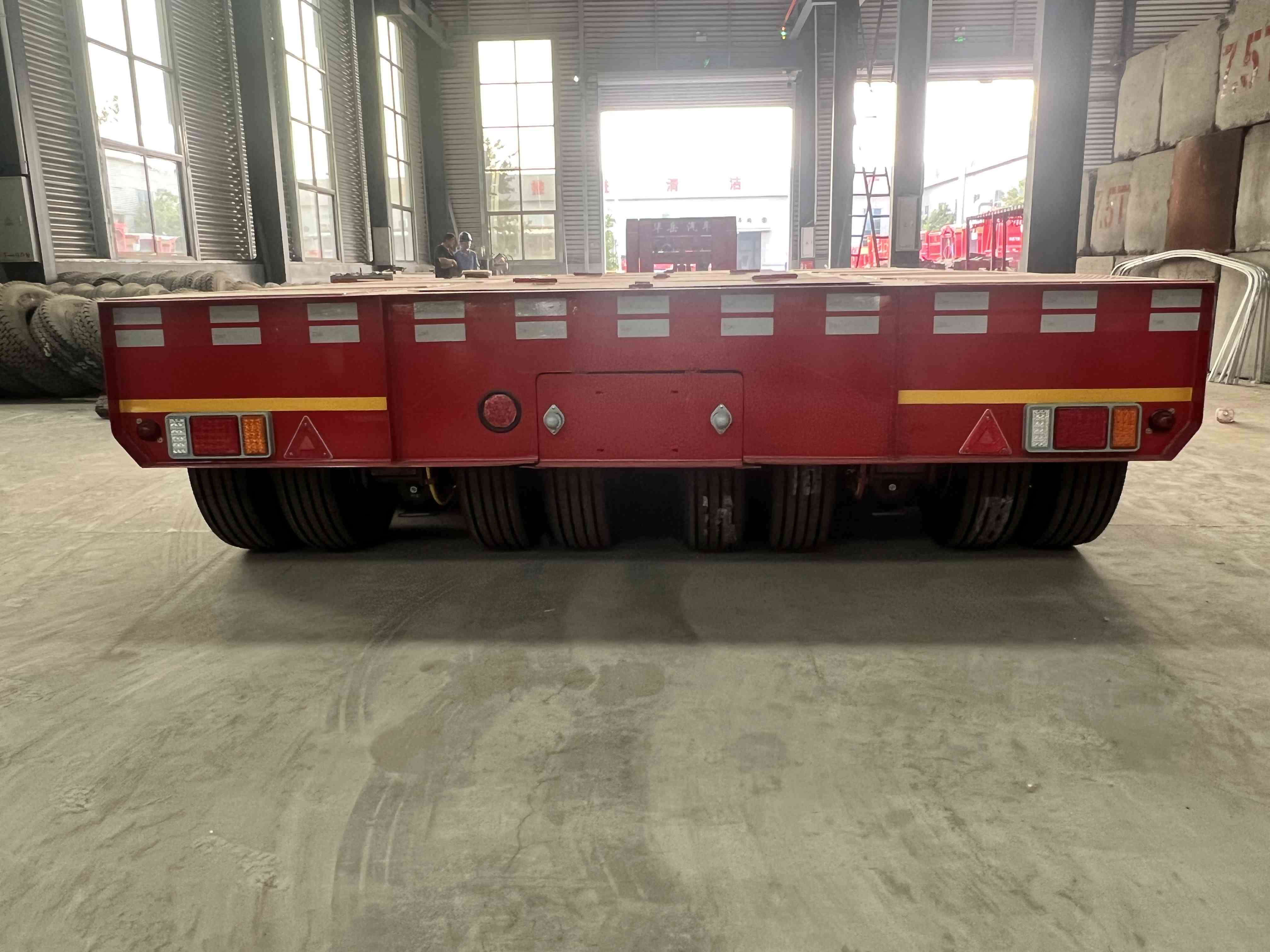 Detailed close-up view of the rear wheel arrangement on the custom 4-line 8-axle RGN lowboy trailer, explicitly highlighting the 4-line configuration where **each axle line contains two separate axles and a total of eight tires per line** for maximum load distribution