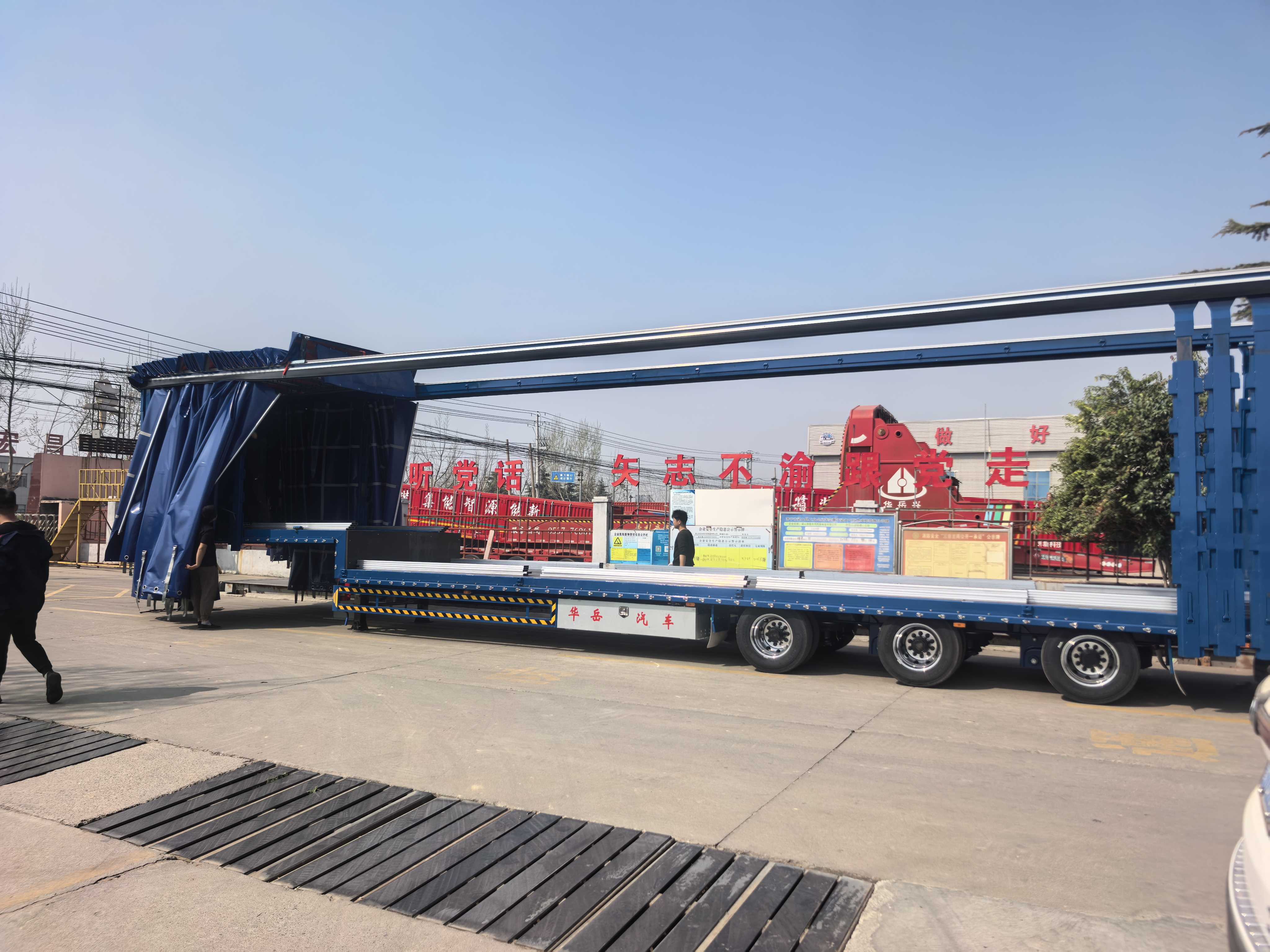 Side view of the HUAYUE 3-axle curtain side trailer with curtains fully opened, demonstrating the 3-way wide-open access for easy forklift loading and unloading of palletized beverages