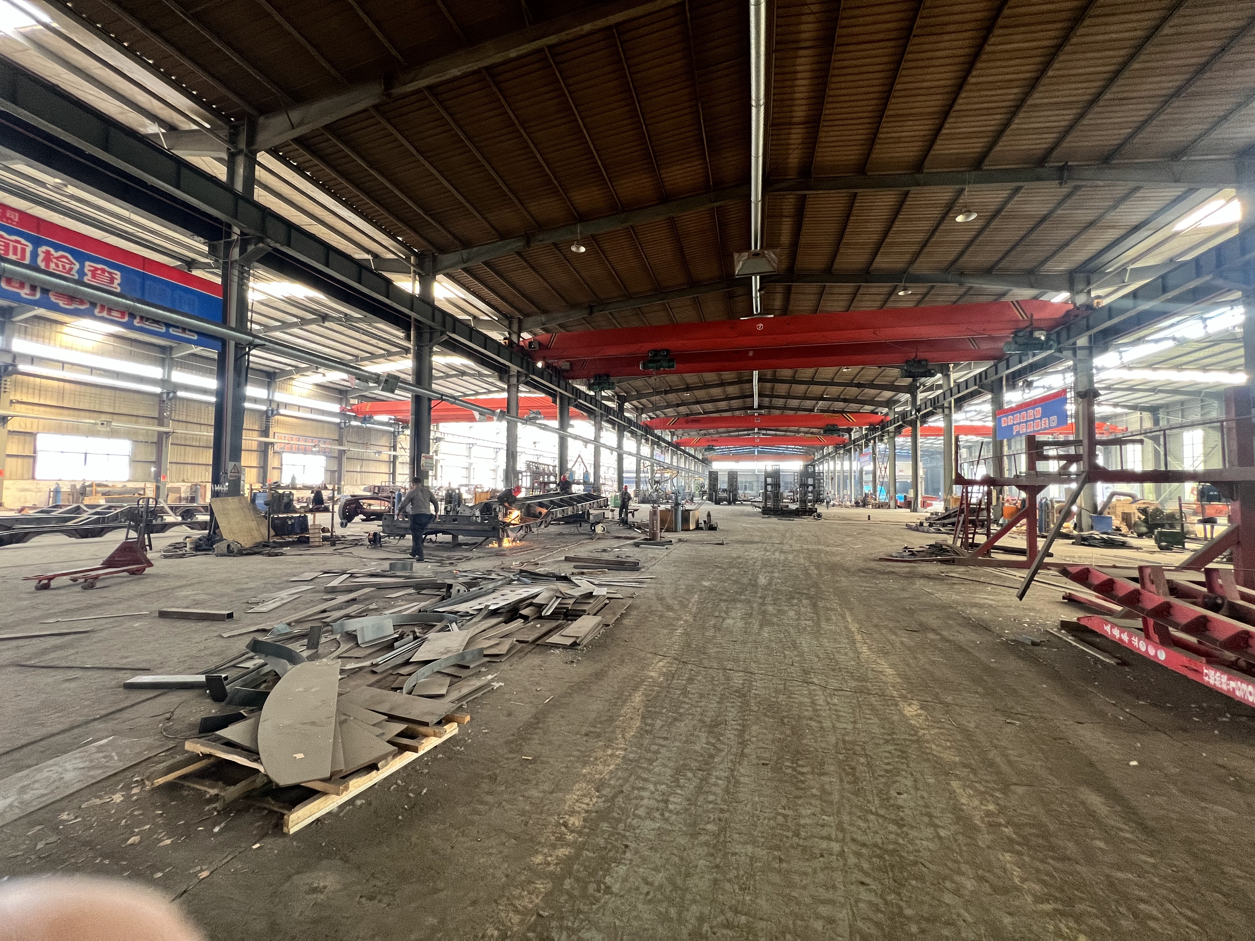 Panoramic view of HUAYUE's massive heavy-duty trailer manufacturing plant, showcasing active production lines and high-capacity overhead cranes