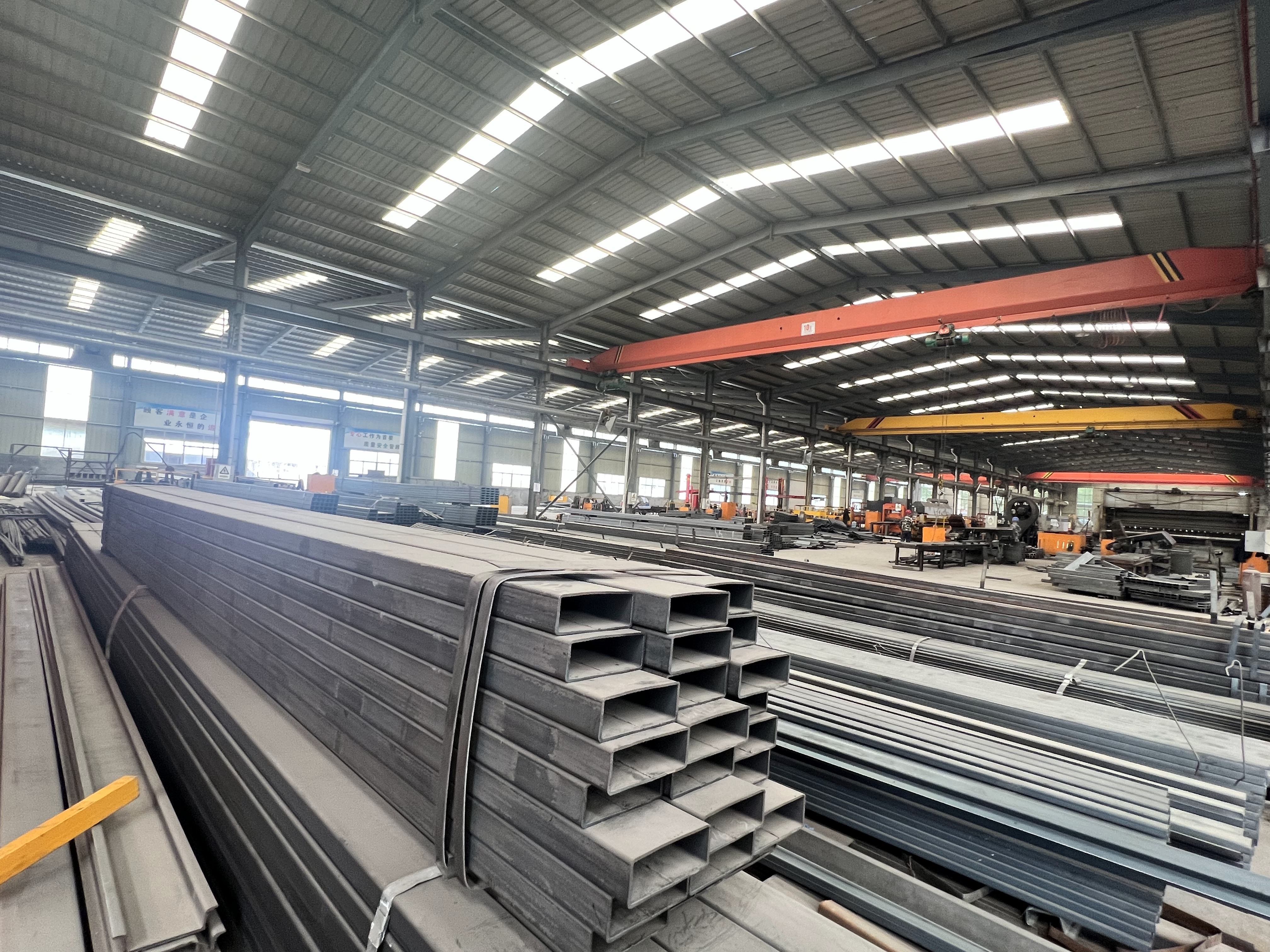 Massive inventory of high-strength steel beams and tubes inside the HUAYUE factory, ensuring zero supply chain delays for custom trailer orders