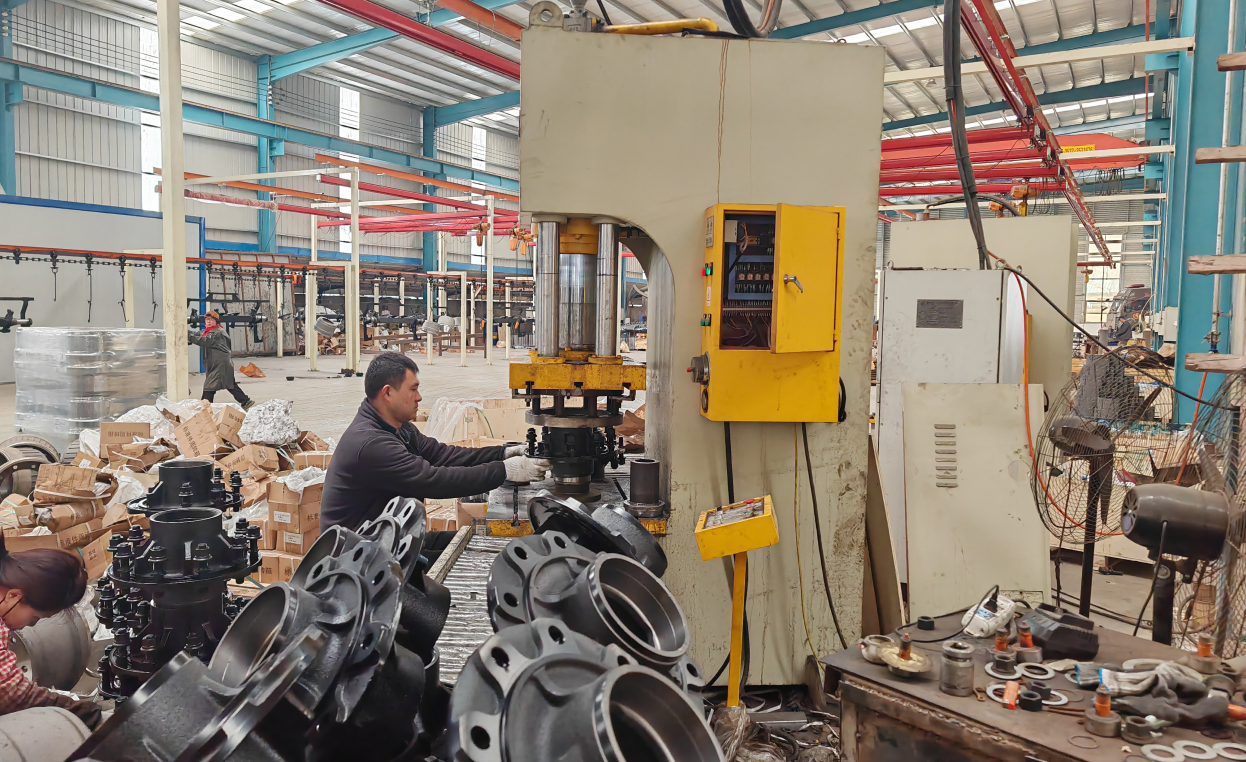 A skilled HUAYUE factory worker operating specialized heavy machinery to process customized trailer components in-house