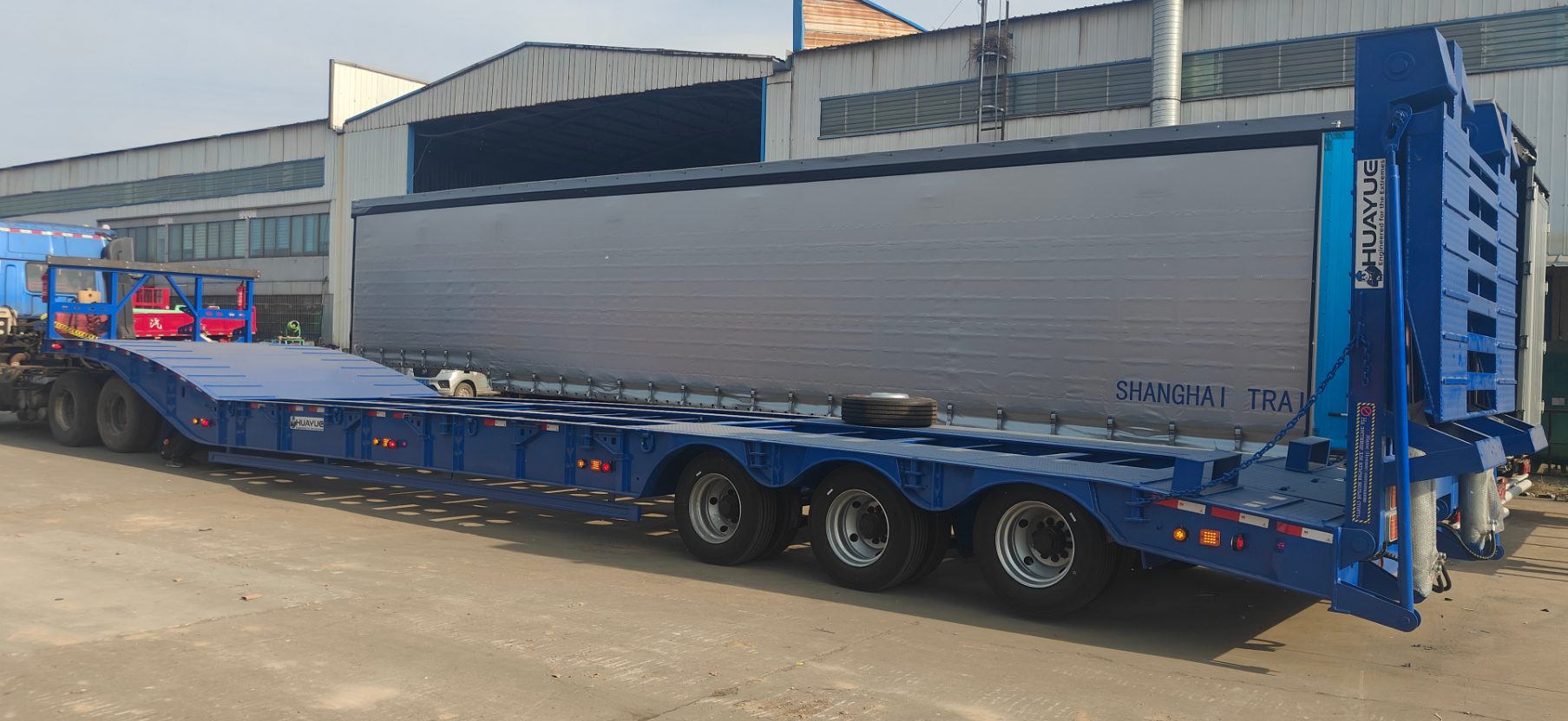 A panoramic side view of HUAYUE's custom 3-axle heavy-duty lowbed trailer, showcasing its ultra-low working platform and high-strength folding ramps.
