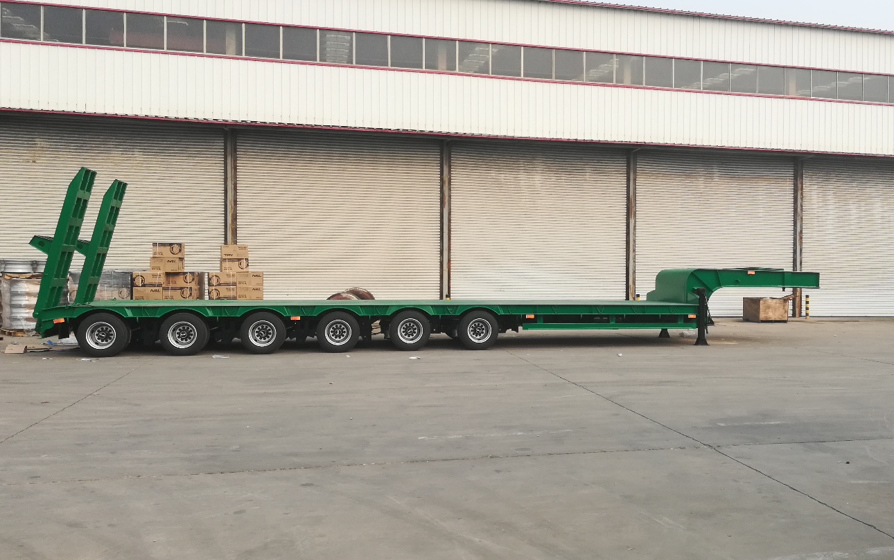 Full side profile of the HUAYUE 6-axle extendable heavy-duty lowbed trailer, showcasing its premium green polyurethane finish and robust chassis designed for 60-ton payloads.