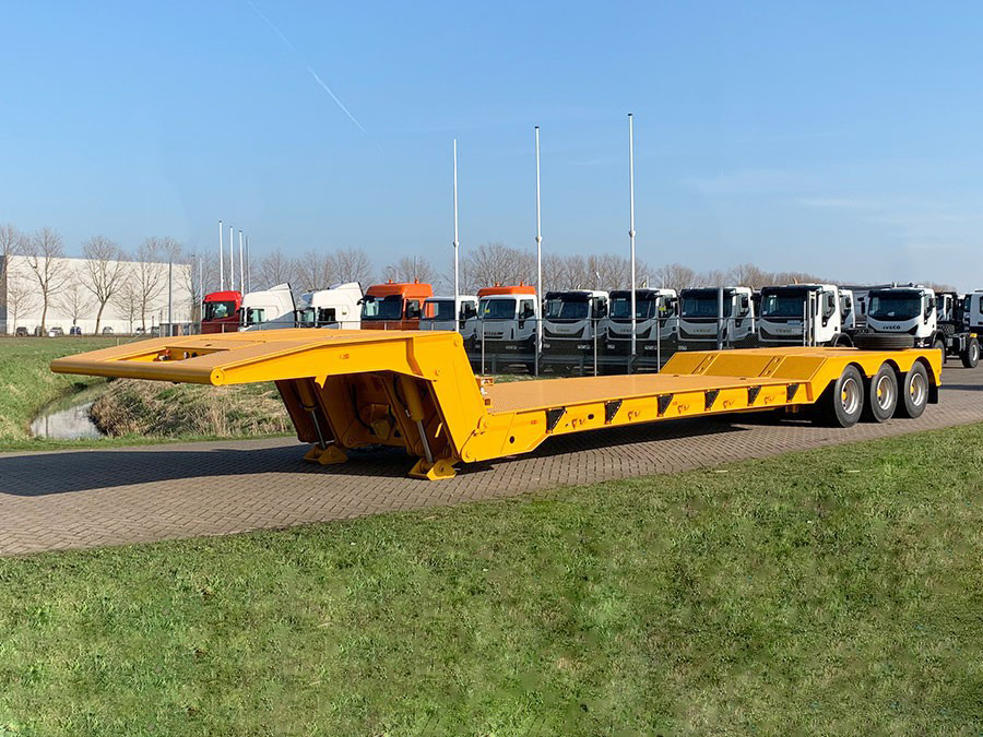 Front-side perspective of the HUAYUE 3-axle folding gooseneck lowbed trailer, highlighting its heavy-duty hydraulic lifting cylinders and the expansive anti-slip checkered steel working deck.