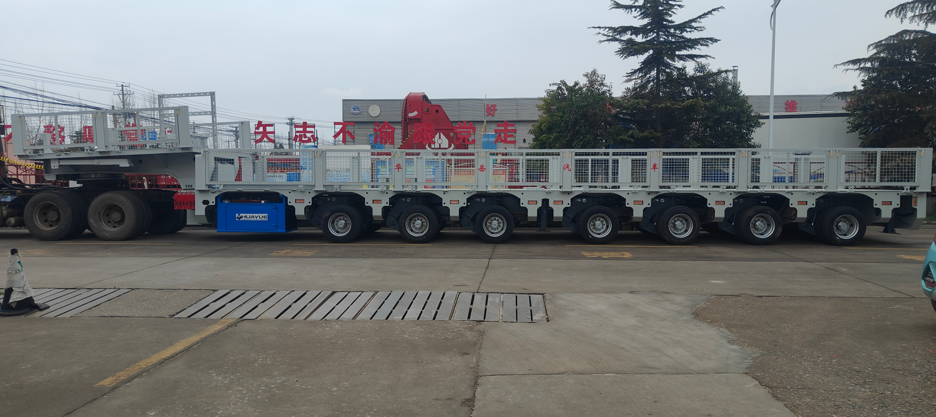 Full side profile of the HUAYUE multi-axle mobile substation trailer, showcasing its heavy-duty chassis and insulated safety fencing customized for heavy transformers and high-voltage switchgear.