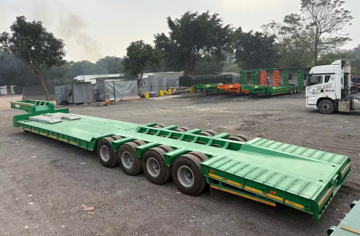 HUAYUE multi-axle heavy-duty lowbed trailer parked at a delivery site, featuring a multi-line chassis structure designed to comply with Vietnam's Circular 46 axle load regulations.
