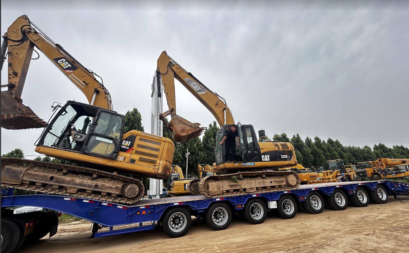 Two heavy CAT excavators securely parked on the deck of a HUAYUE trailer. High-standard decking material provides an extreme friction coefficient, ensuring metal tracks do not slide laterally during heavy-haul transport.