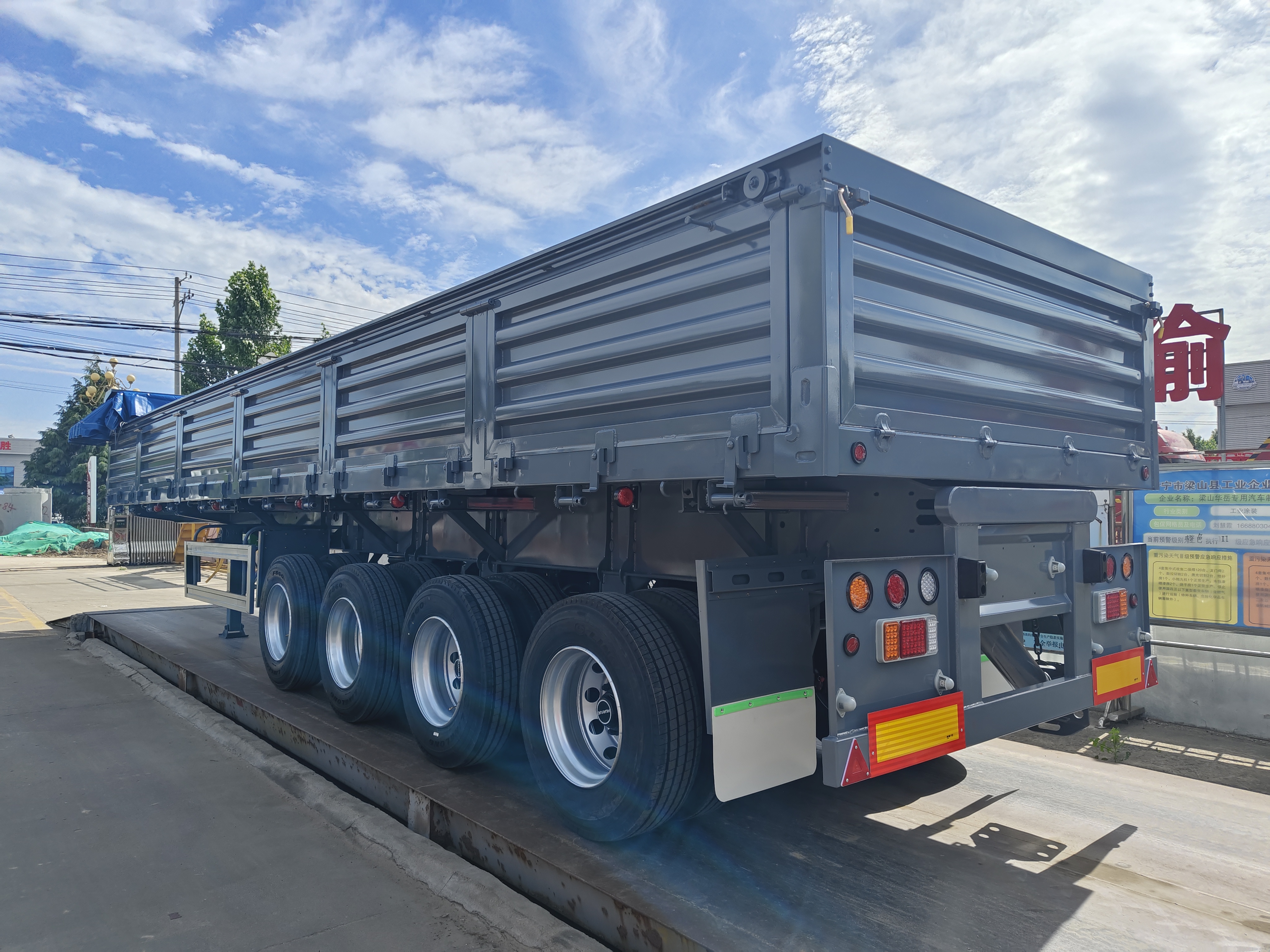 Close-up of the smooth, dead-corner-free box and the front-mounted heavy-duty multi-stage hydraulic lifting system of a U-shape rear dump semi-trailer.