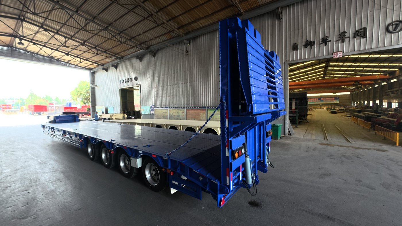 Detailed showcase of the HUAYUE lowbed semi-trailer's signature ultra-low drop deck and high-strength steel variable cross-section torsion-resistant main beam structure.