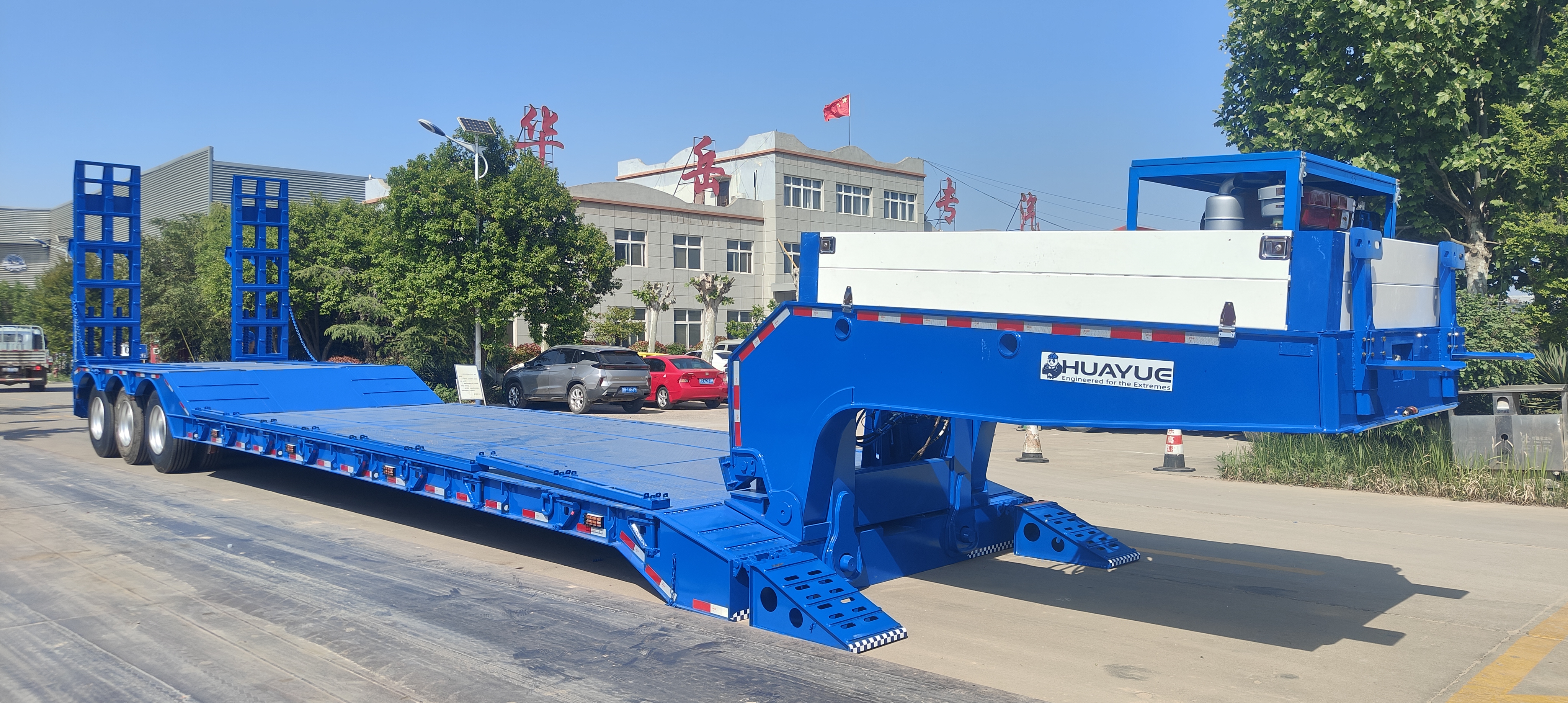 HUAYUE hydraulic detachable gooseneck lowbed trailer displaying its chassis status after gooseneck separation, with the front beam resting flat on the ground, providing an absolutely safe front-loading channel for heavy machinery.