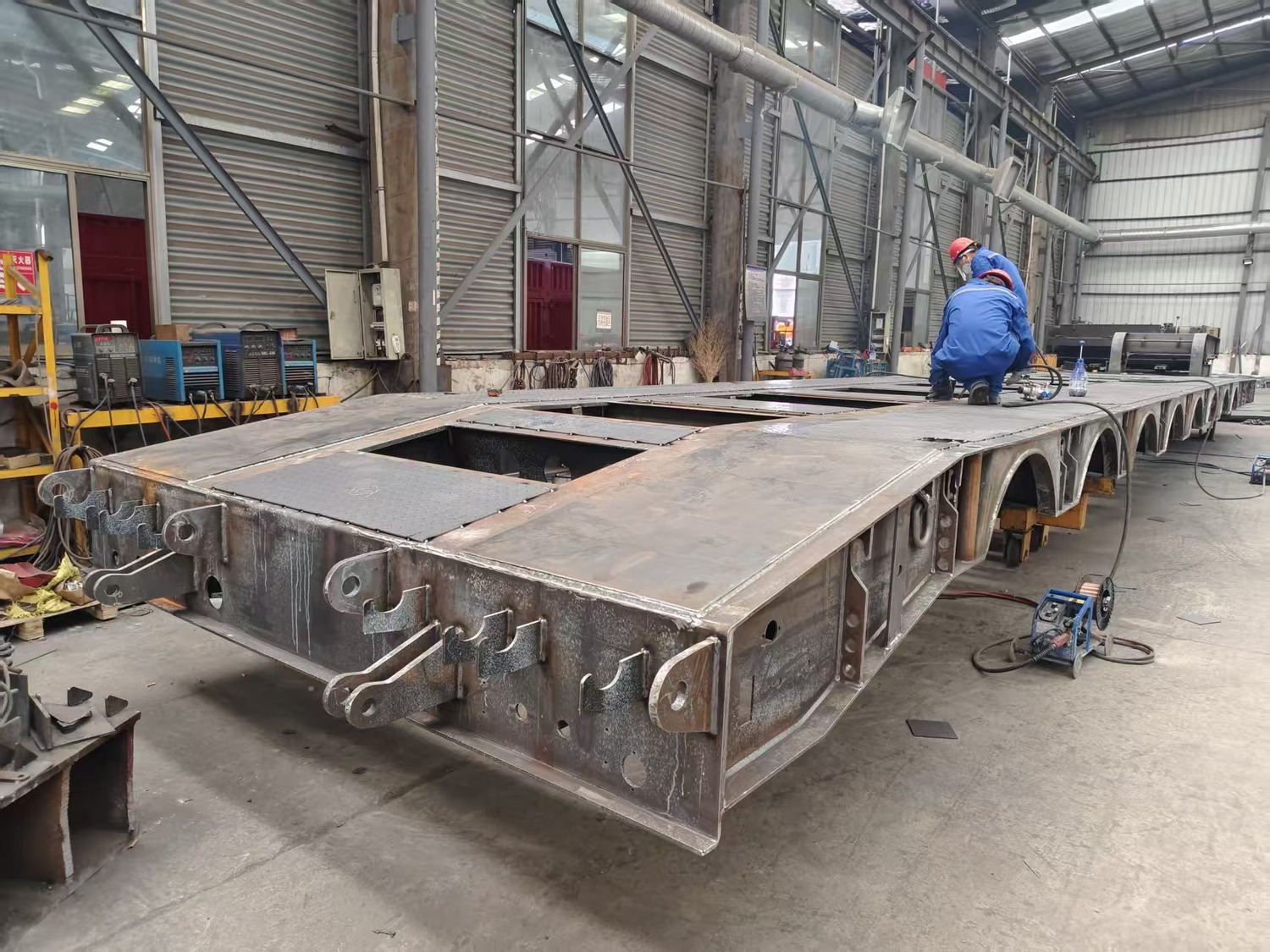 Lowbed trailer deck and frame under fabrication in a factory workshop