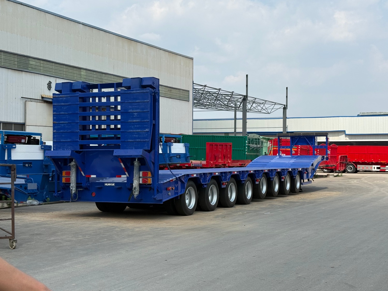 Blue HUAYUE 8-axle lowbed trailer with rear ramps and heavy-duty running gear