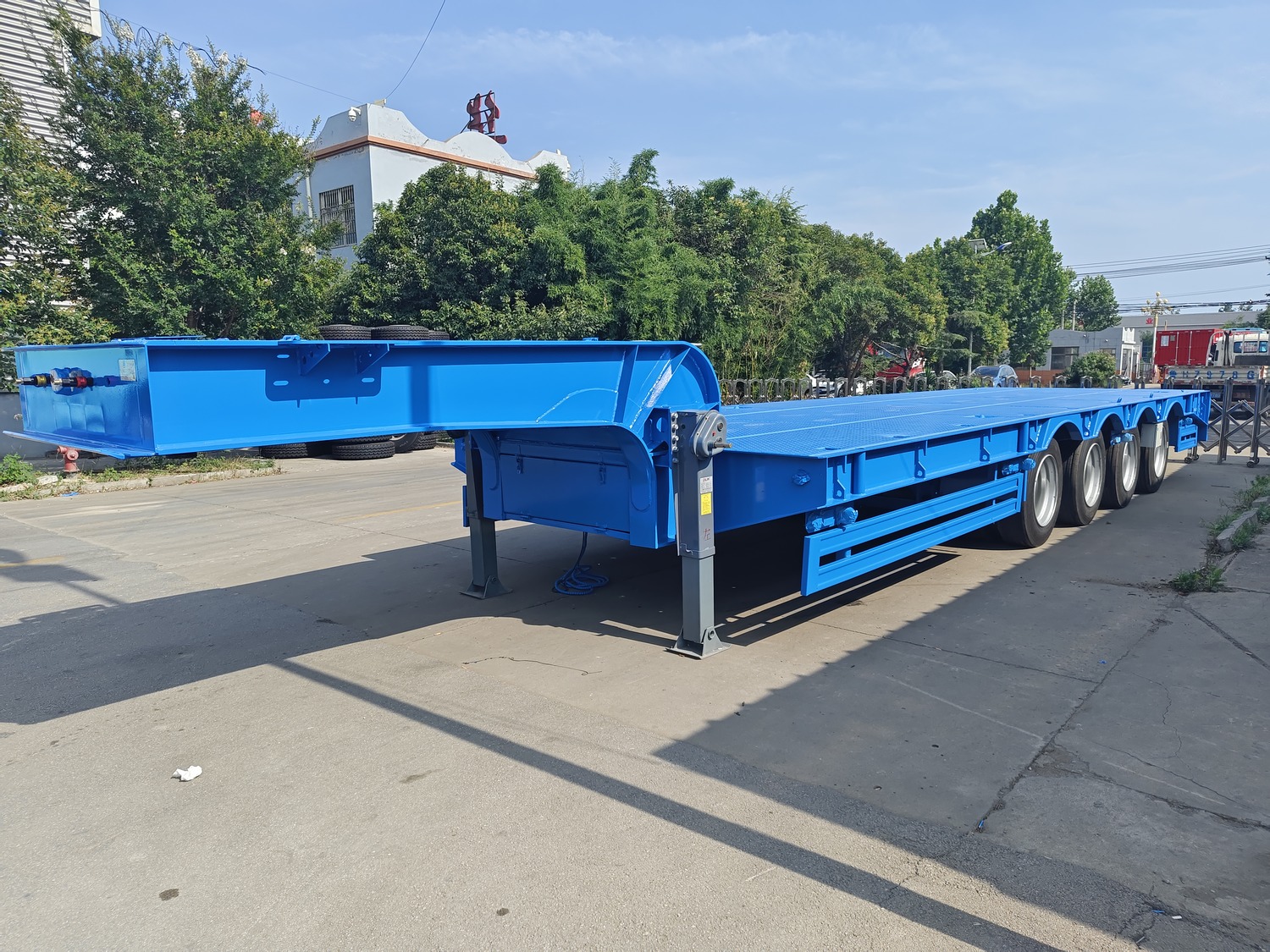 Blue 4-axle lowbed semi-trailer shown outside the Huayue factory